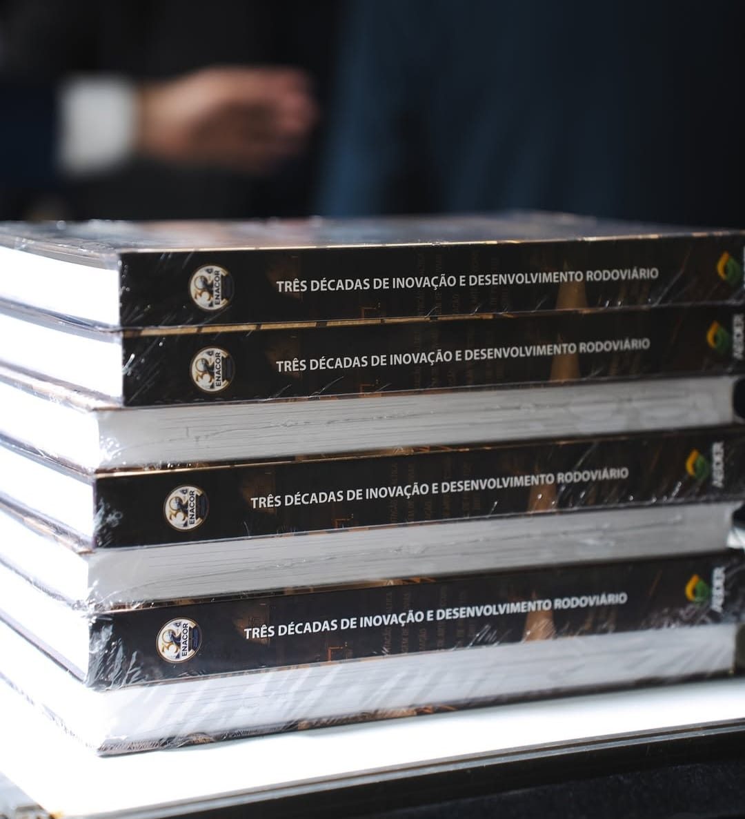 Exemplares do livro Três décadas de inovação e desenvolvimento rodoviário empilhados